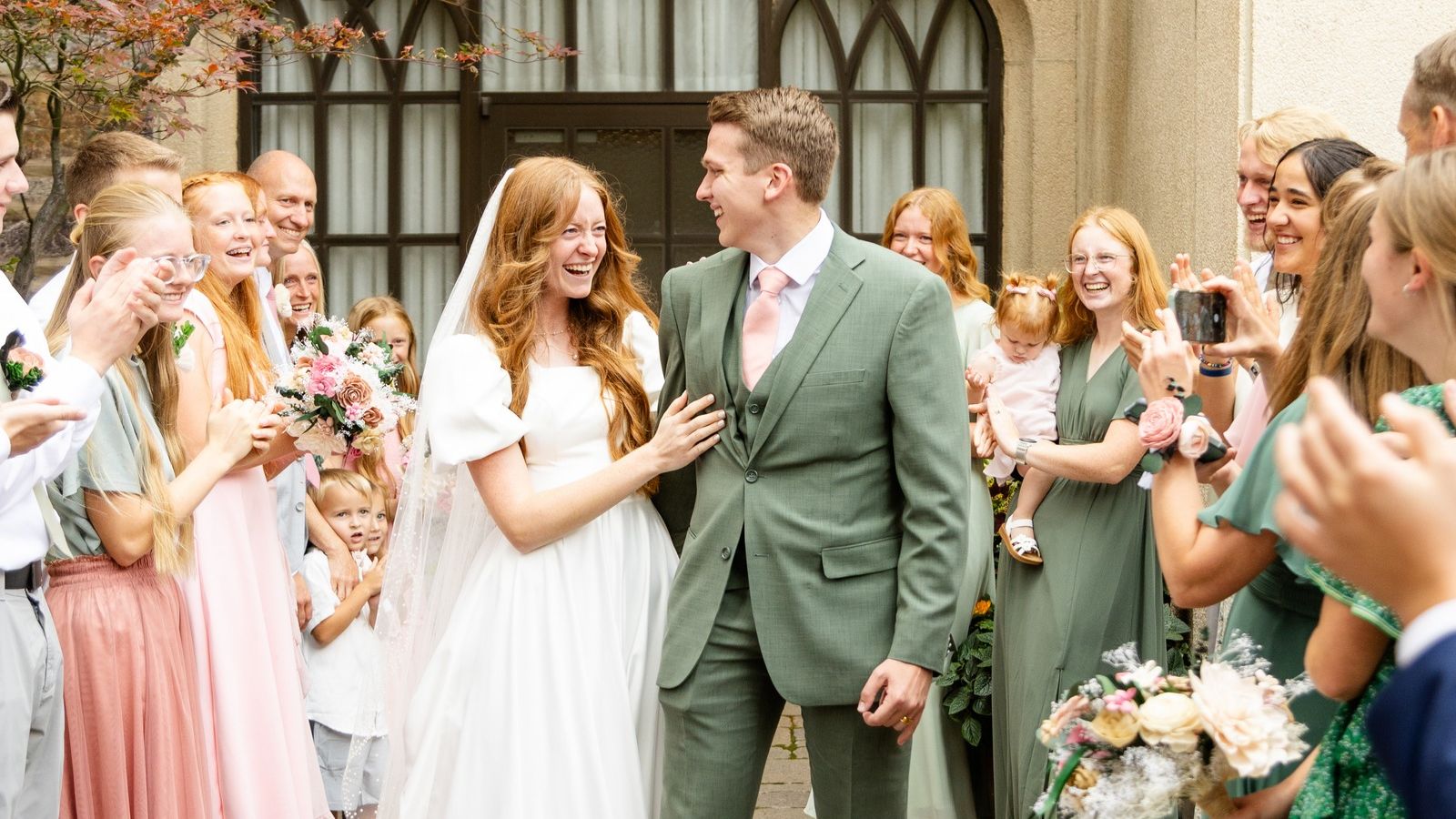 Brianne and Josh smiling together as family and friends celebrate their summer wedding in Logan, Utah. Copy